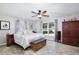 Bright bedroom with wood floors, ceiling fan, a window and a storage bench at the end of the bed at 623 Green Meadow Ave, Maitland, FL 32751