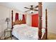 Comfortable bedroom with a four-poster bed, ceiling fan, and bright red closet doors at 623 Green Meadow Ave, Maitland, FL 32751
