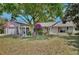 A lovely single-story home boasts manicured lawn, mature trees, and pergola covered walkway to the front door at 623 Green Meadow Ave, Maitland, FL 32751