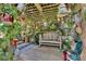 Inviting outdoor pergola with bench seating surrounded by potted plants and whimsical decorations at 623 Green Meadow Ave, Maitland, FL 32751
