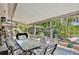 Screened patio with dining table set and view of the landscaped yard with birdhouses and flowers at 623 Green Meadow Ave, Maitland, FL 32751