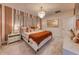 Stylish bedroom with a modern chandelier, striped accent wall, and tasteful decor at 6301 Sand Skipper Rd, Orlando, FL 32821