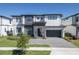 Stunning two-story home boasting modern design, stone accents, a well-manicured lawn and a gray paved driveway at 6301 Sand Skipper Rd, Orlando, FL 32821