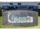 Overhead view of a private screened-in pool with jacuzzi and float, surrounded by lush lawn at 6301 Sand Skipper Rd, Orlando, FL 32821