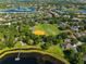 Aerial view showcasing a community with a park, lake access, and green spaces amidst residential homes at 709 Cricklewood Ter, Lake Mary, FL 32746
