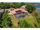 Aerial view of the property with a screened-in pool, beautiful landscaping, and a view of the lake at 709 Cricklewood Ter, Lake Mary, FL 32746