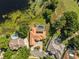 Overhead view of the home featuring a screened-in pool, lush greenery, and water views at 709 Cricklewood Ter, Lake Mary, FL 32746