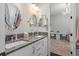 Elegant bathroom with double sinks, granite counters, modern fixtures, and a stylish doorway view to a area at 709 Cricklewood Ter, Lake Mary, FL 32746