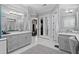 Elegant primary bathroom with dual vanities, white marble floors, and entry to a walk-in closet at 709 Cricklewood Ter, Lake Mary, FL 32746