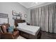 Comfortable bedroom with a leather chair, a wooden bed frame, and framed pictures on the wall at 709 Cricklewood Ter, Lake Mary, FL 32746