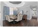 Dining room featuring hardwood floors, a modern chandelier, a large dining table, and soft neutral chairs at 709 Cricklewood Ter, Lake Mary, FL 32746