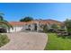 Inviting single-story home with a terra cotta roof, three-car garage, and beautifully landscaped front yard at 709 Cricklewood Ter, Lake Mary, FL 32746