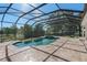 The caged pool area features a pool, a hot tub, and a spacious deck with views of the lush backyard at 709 Cricklewood Ter, Lake Mary, FL 32746