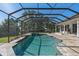 Beautiful pool and spa inside a screened enclosure, surrounded by a tiled deck and lush landscaping at 709 Cricklewood Ter, Lake Mary, FL 32746
