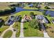 Aerial view of a home with a long driveway, surrounded by lush landscaping and a serene lake at 7351 Spring Mountain Ln, Yalaha, FL 34797