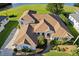 Aerial view of residence, highlighting its prominent roofline, professional landscaping, and access to water at 7351 Spring Mountain Ln, Yalaha, FL 34797