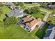 Aerial view of a well-maintained house, green lawn, screened pool, and brown roof at 7351 Spring Mountain Ln, Yalaha, FL 34797