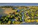 Panoramic aerial view of a lakefront community featuring lush greenery, waterways, and residential homes at 7351 Spring Mountain Ln, Yalaha, FL 34797