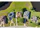 Overhead view of residences with manicured lawns and landscaping situated by a picturesque lake at 7351 Spring Mountain Ln, Yalaha, FL 34797