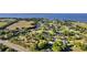 An aerial perspective showcases the real estate's serene community by the water, surrounded by mature trees at 7351 Spring Mountain Ln, Yalaha, FL 34797