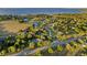 Scenic aerial view of a lakeside community with lush landscaping and a tennis court at 7351 Spring Mountain Ln, Yalaha, FL 34797