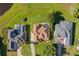 Birds eye view of homes boasting manicured lawns, beautiful landscaping, and a tranquil lake setting at 7351 Spring Mountain Ln, Yalaha, FL 34797