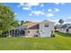 Large backyard features a screened enclosure, lush lawn, and white vinyl fence at 7351 Spring Mountain Ln, Yalaha, FL 34797