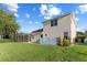 The backyard features a manicured lawn, privacy fencing, and a screened in pool area, offering privacy and relaxation at 7351 Spring Mountain Ln, Yalaha, FL 34797