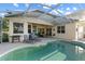 A view of the backyard swimming pool and patio area featuring a built in outdoor bar and relaxing lounge seating at 7351 Spring Mountain Ln, Yalaha, FL 34797