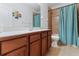 Bathroom features a wood vanity, light countertop, shower and toilet at 7351 Spring Mountain Ln, Yalaha, FL 34797