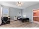 Bedroom with workspace, ceiling fan, light-colored walls and floors, and adjacent bathroom at 7351 Spring Mountain Ln, Yalaha, FL 34797