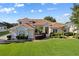 Charming home featuring lush landscaping, a well-manicured lawn, and a welcoming front entrance at 7351 Spring Mountain Ln, Yalaha, FL 34797