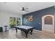 Open game room with a view to the back yard and an eye-catching accent wall at 7351 Spring Mountain Ln, Yalaha, FL 34797