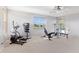 Spacious home gym with stationary bike, weight bench, tv, and large window with outside view at 7351 Spring Mountain Ln, Yalaha, FL 34797