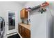 View of laundry room with washer, cabinets, countertop and refrigerator with access to the outside at 7351 Spring Mountain Ln, Yalaha, FL 34797