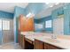 Well-lit main bathroom with double sinks, wood cabinets, and a glass-enclosed shower at 7351 Spring Mountain Ln, Yalaha, FL 34797