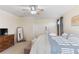 Bedroom with carpeting, ceiling fan, dresser, mirror and a large window at 7351 Spring Mountain Ln, Yalaha, FL 34797