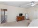 Bedroom with light colored carpet and a wood dresser featuring a tv and large mirror at 7351 Spring Mountain Ln, Yalaha, FL 34797