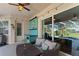 Relaxing covered lanai featuring outdoor seating, a built in bar, and sliding doors to the screened pool area at 7351 Spring Mountain Ln, Yalaha, FL 34797