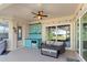 Covered patio with outdoor seating, an outdoor kitchen, and sliding glass doors that lead to the pool area at 7351 Spring Mountain Ln, Yalaha, FL 34797