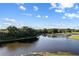 Scenic view of a tranquil pond surrounded by lush trees, reflecting the clear blue sky at 7351 Spring Mountain Ln, Yalaha, FL 34797
