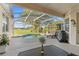 The pool is screened in with a beautiful backyard view of a lush green lawn and blue skies at 7351 Spring Mountain Ln, Yalaha, FL 34797