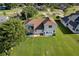 The backyard features a screened-in pool, lush lawn, and a view of surrounding greenery at 7351 Spring Mountain Ln, Yalaha, FL 34797