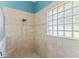 Tiled shower featuring glass block window and bench seating at 7351 Spring Mountain Ln, Yalaha, FL 34797