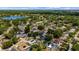 Picturesque aerial shot showcases home with in-ground pool, solar panels, and community lake at 8444 Sandberry Blvd, Orlando, FL 32819