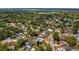 Wide aerial view of home with fenced pool, situated near a tranquil lake and verdant trees at 8444 Sandberry Blvd, Orlando, FL 32819
