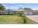 Charming single-story home with well-manicured lawn, brick driveway, and attached two-car garage at 8444 Sandberry Blvd, Orlando, FL 32819