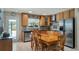 Bright kitchen featuring wooden cabinetry, stainless steel appliances, and adjacent dining area with seating for six at 8444 Sandberry Blvd, Orlando, FL 32819