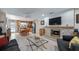 Open-concept living room features a brick fireplace with a wooden mantle, and a view into the adjacent kitchen at 8444 Sandberry Blvd, Orlando, FL 32819