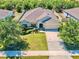 Beautiful aerial view of a well-maintained home with a lush lawn, manicured landscaping and a 2 car garage at 865 Bay Bridge Cir, Apopka, FL 32703